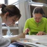 dwie dziewczyny w trakcie prac na konserwacją obrazu.
